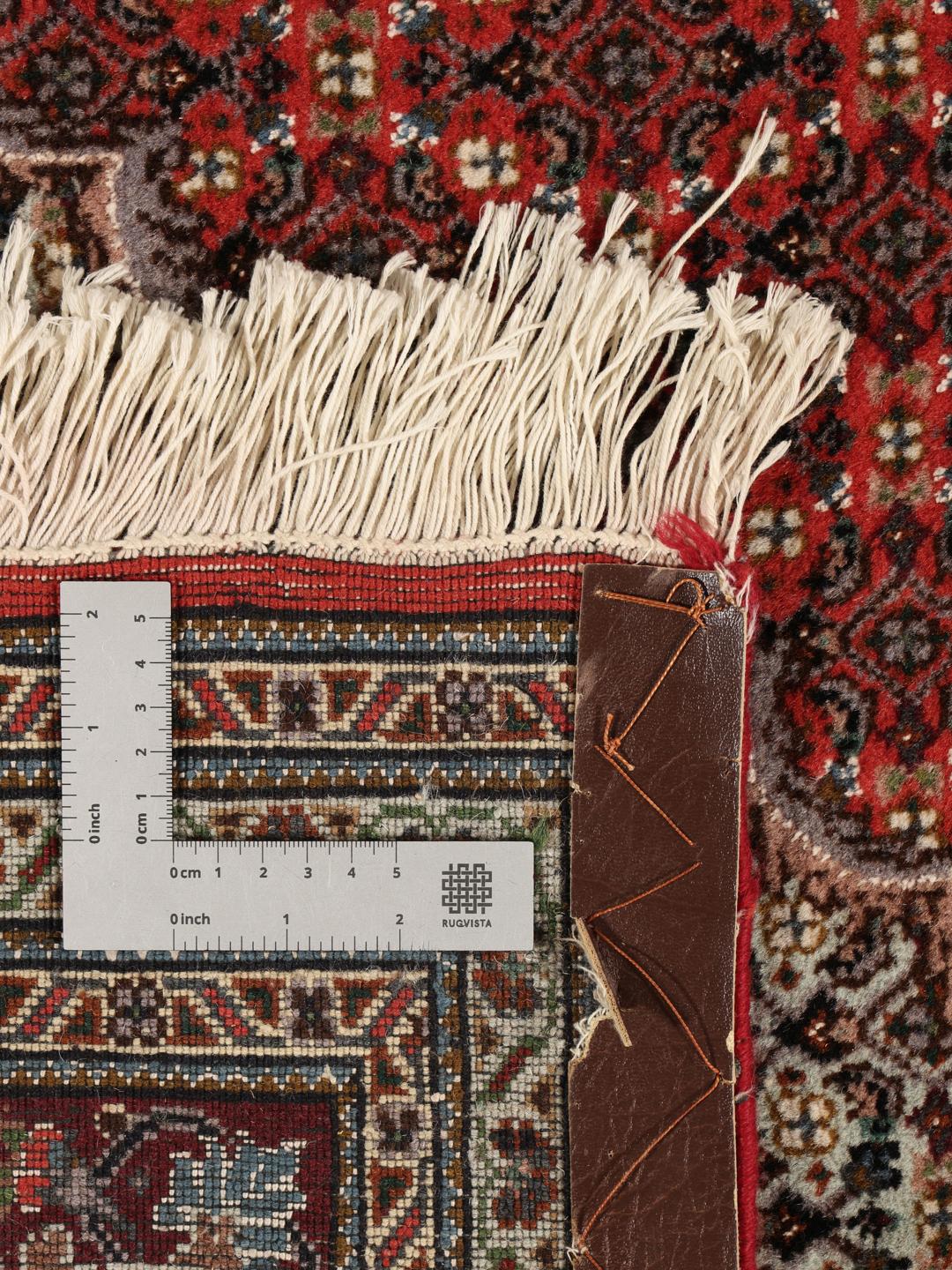 Et håndknyttet Tabriz-tæppe fra Mellemøsten med et detaljeret rødt og beige mønster