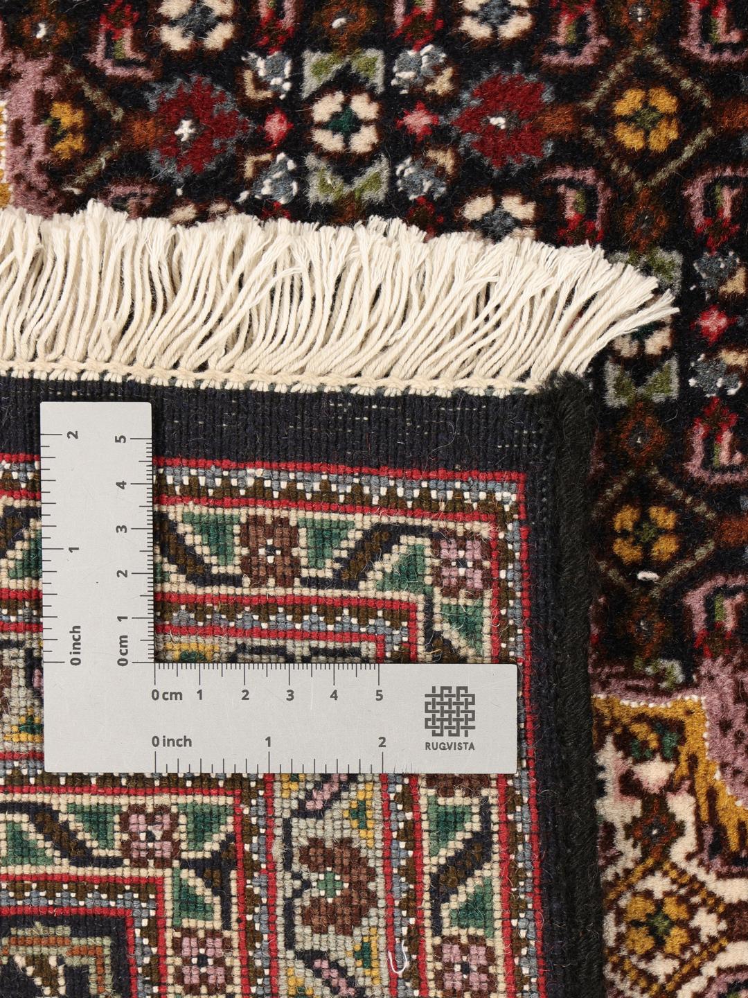 Et håndknyttet Tabriz-tæppe fra Mellemøsten med en mørkerød bund og et detaljeret medaljondesign.