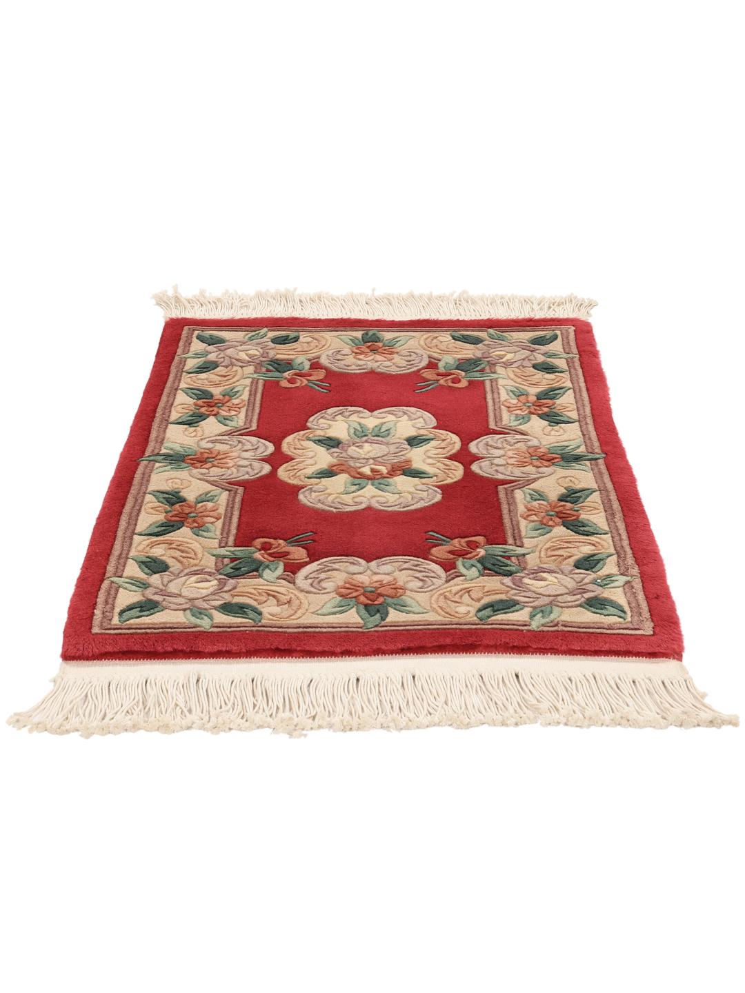 A rectangular hand-knotted Chinese rug with a red field and intricate floral medallion motifs.