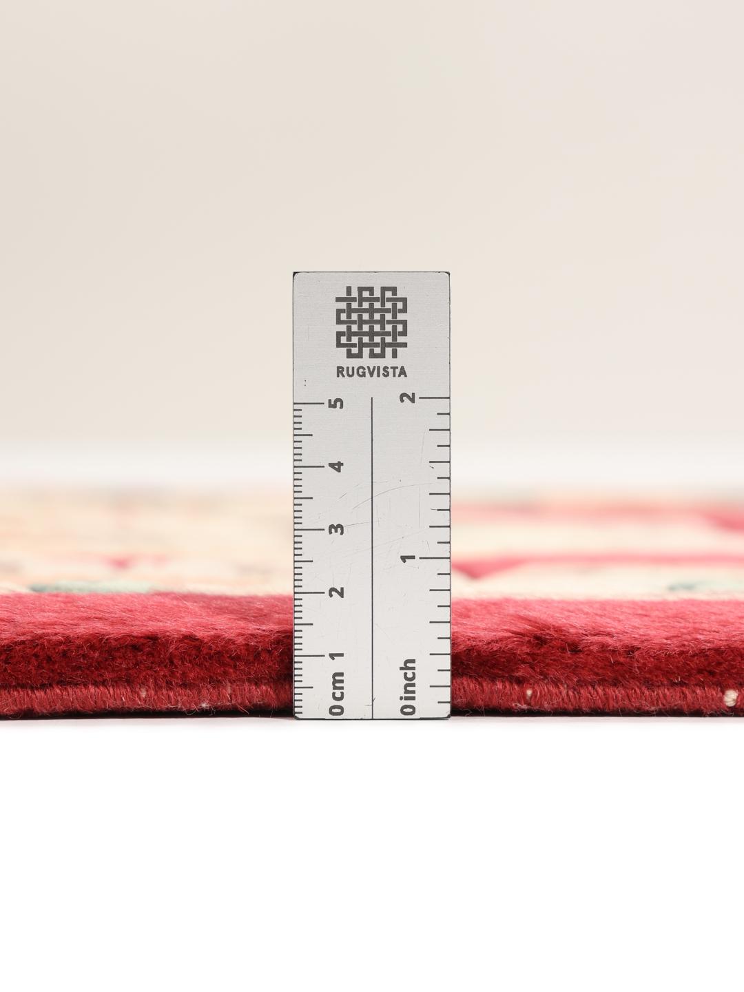 A rectangular hand-knotted Chinese rug with a red field and intricate floral medallion motifs.