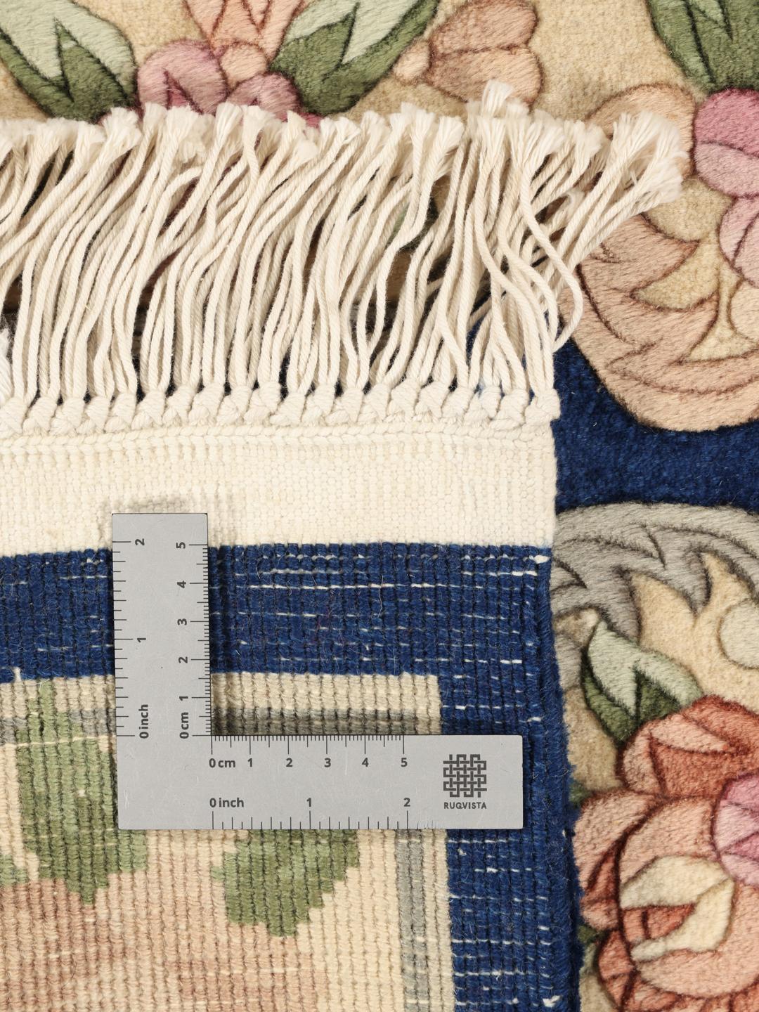 Håndknyttet tæppe fra Kina med blomstermotiver og blå baggrund