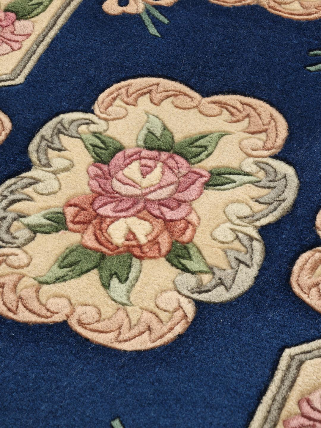 Et håndknyttet kinesisk tæppe med blomstermotiv og blå baggrund
