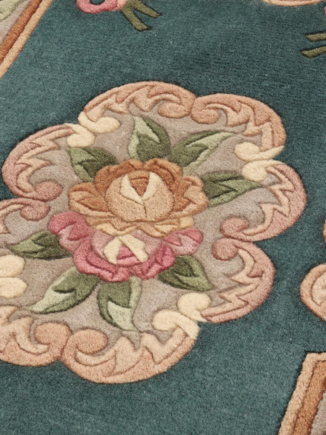 Håndknyttet blomstret tæppe fra Kina med en dyb teal baggrund og bløde rosa rosenmotiver