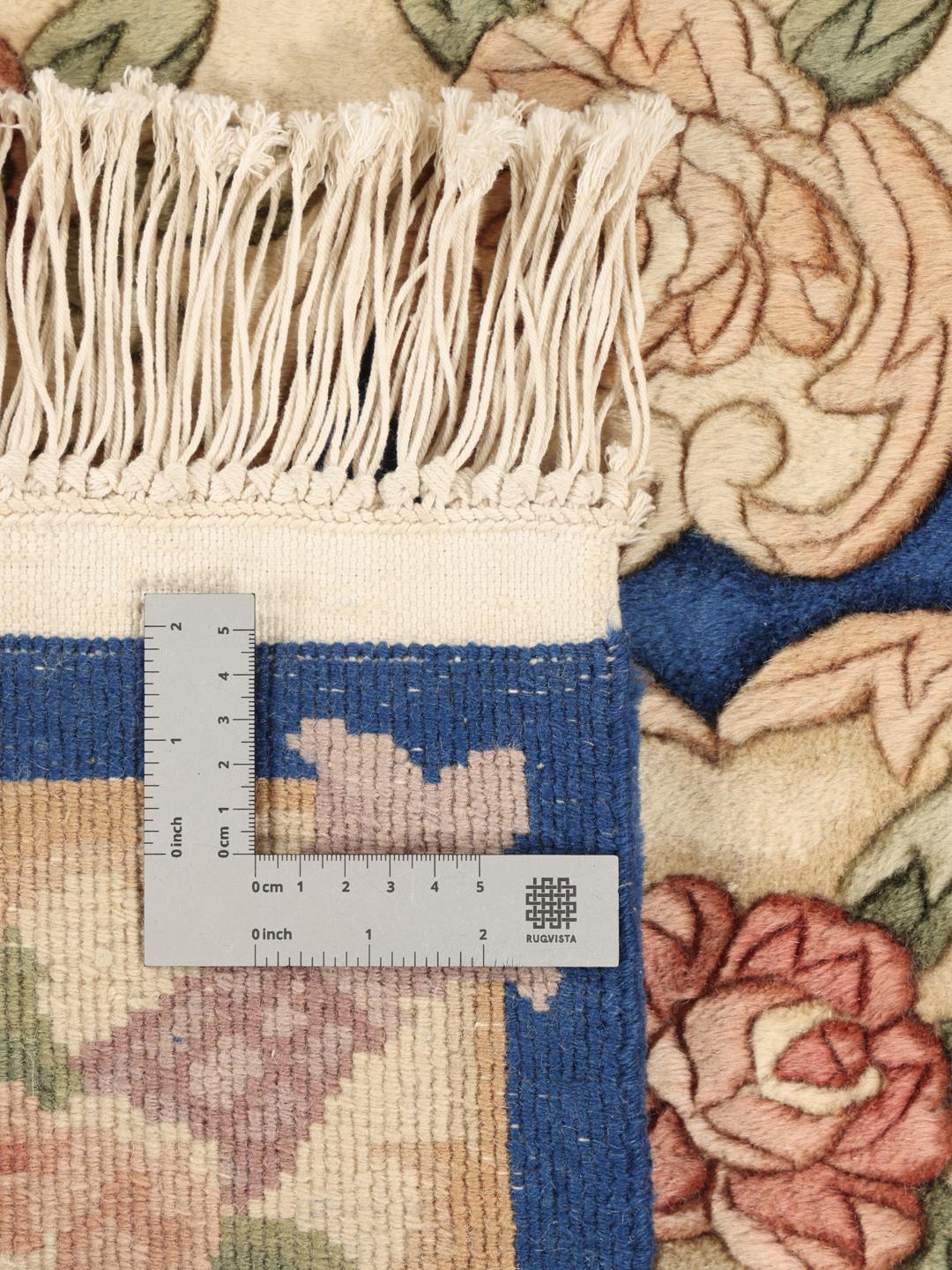 Håndknyttet kinesisk tæppe med blomstermønster i blå og beige.