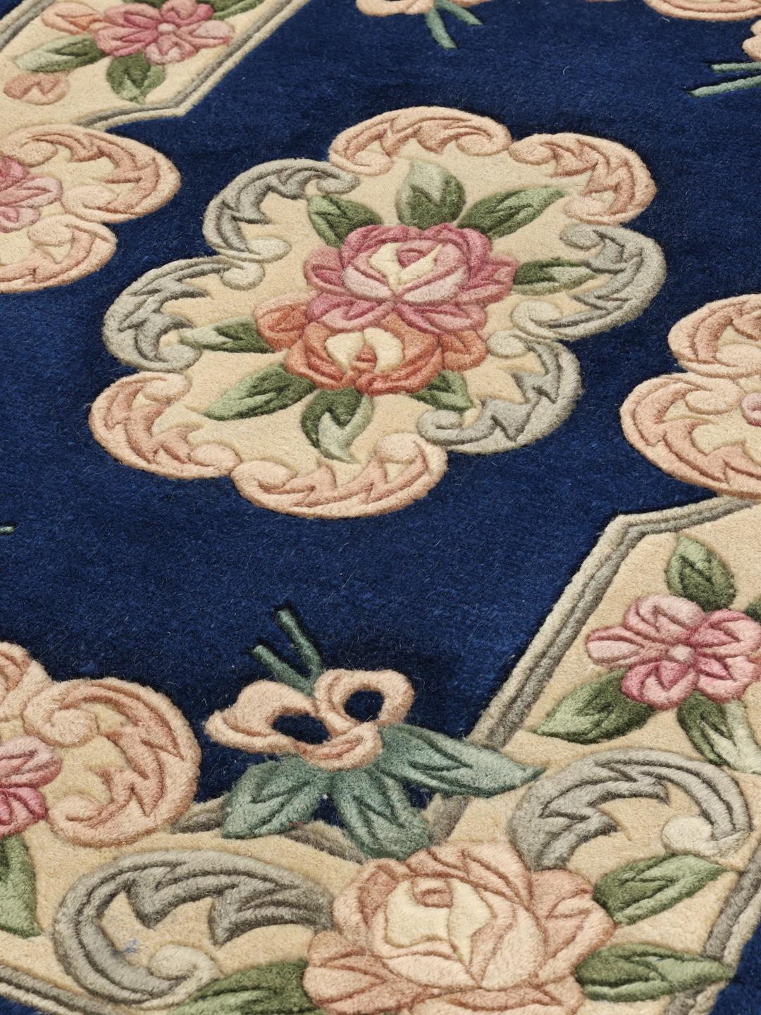 Et håndknyttet rektangulært kinesisk tæppe med blomstermotiver på en dybblå bund