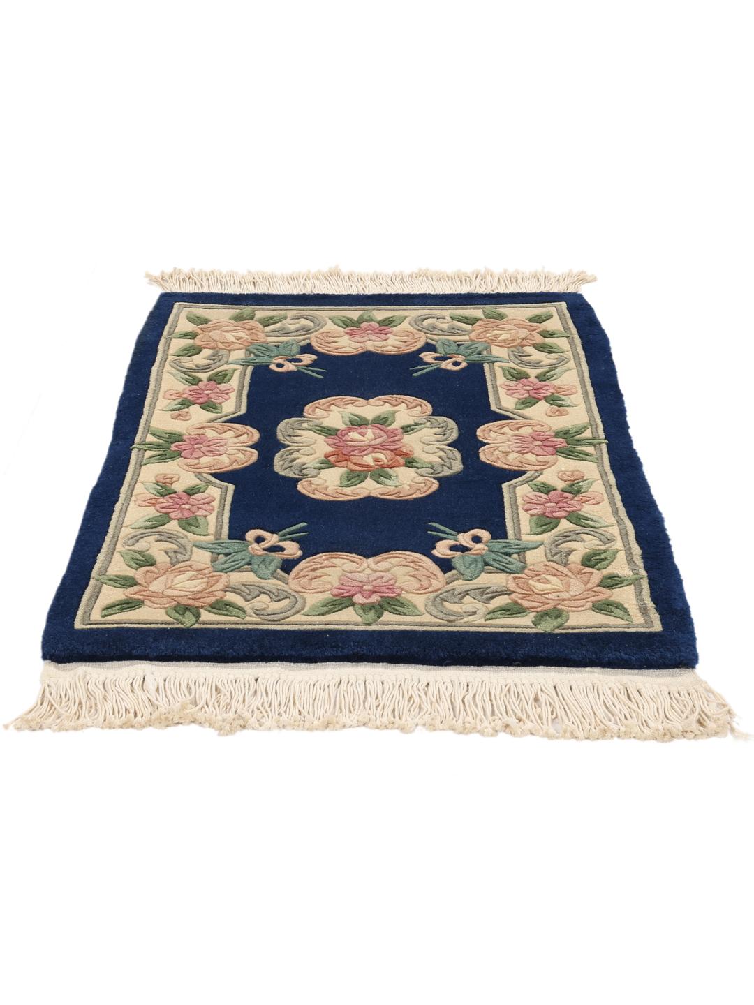 Håndknyttet kinesisk tæppe med blomstermotiver i blå og beige.