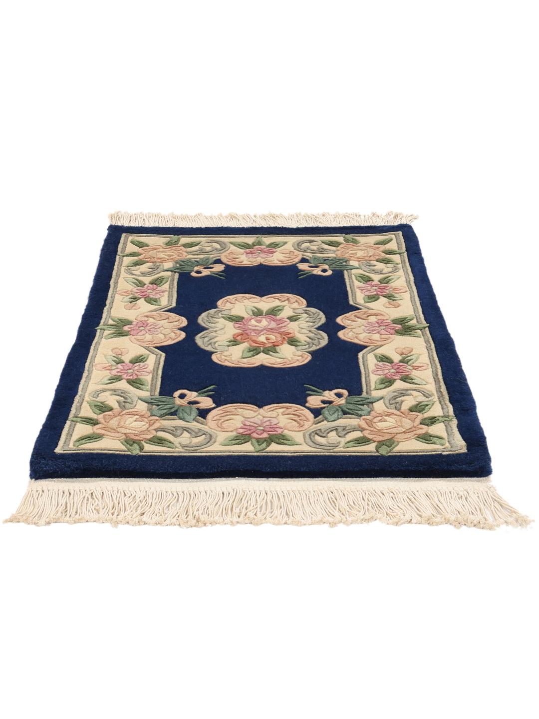A hand-knotted floral rug from China with a deep blue field and pastel rose accents.