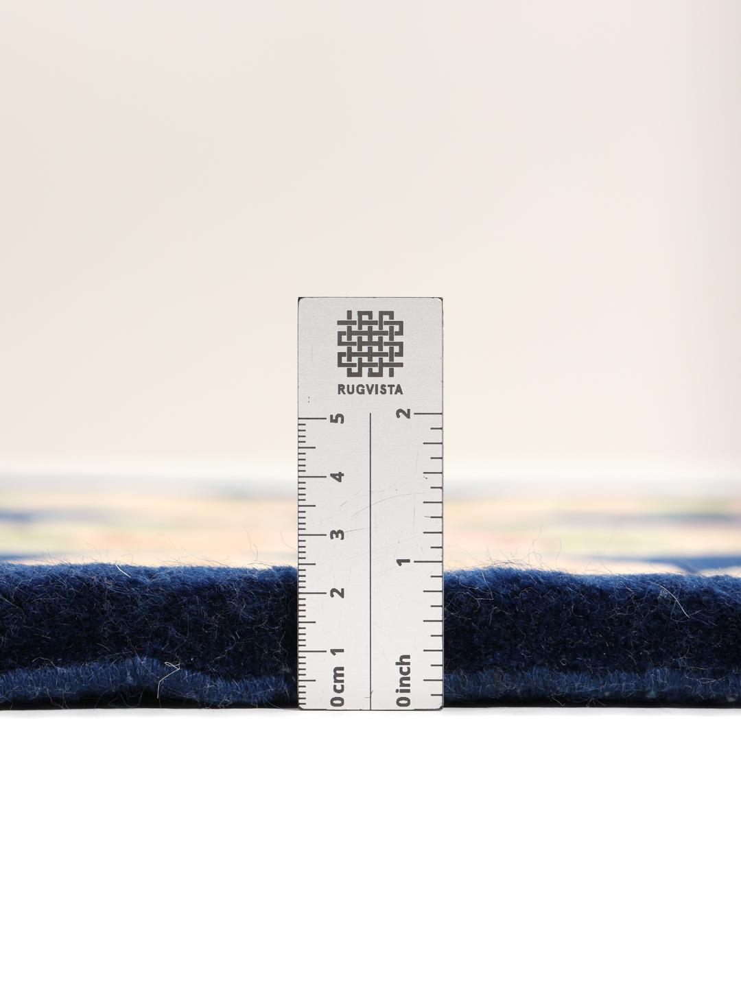 A hand-knotted floral rug from China with a deep blue field and pastel rose accents.