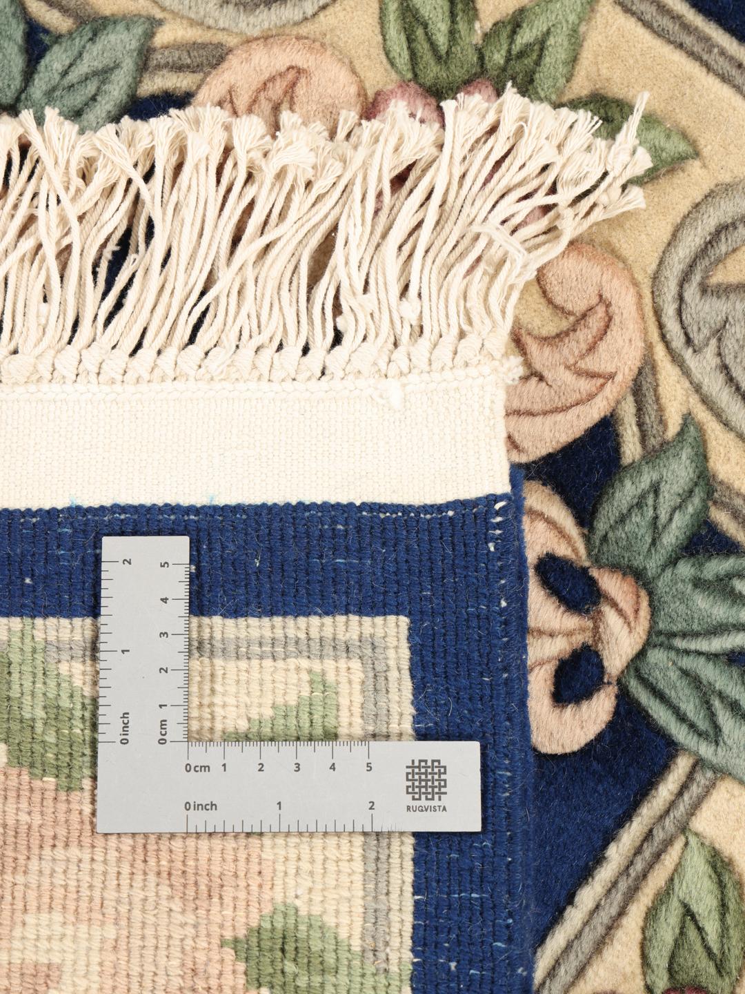 A hand-knotted floral rug from China with a deep blue field and pastel rose accents.