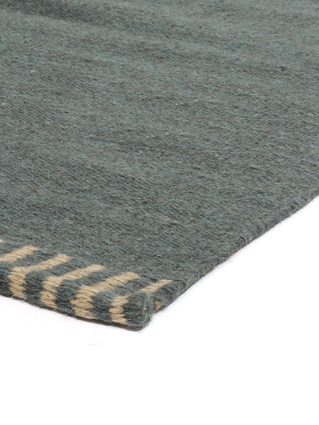 Een vierkant blauw handgeweven tapijt met decoratieve gestreepte randen.