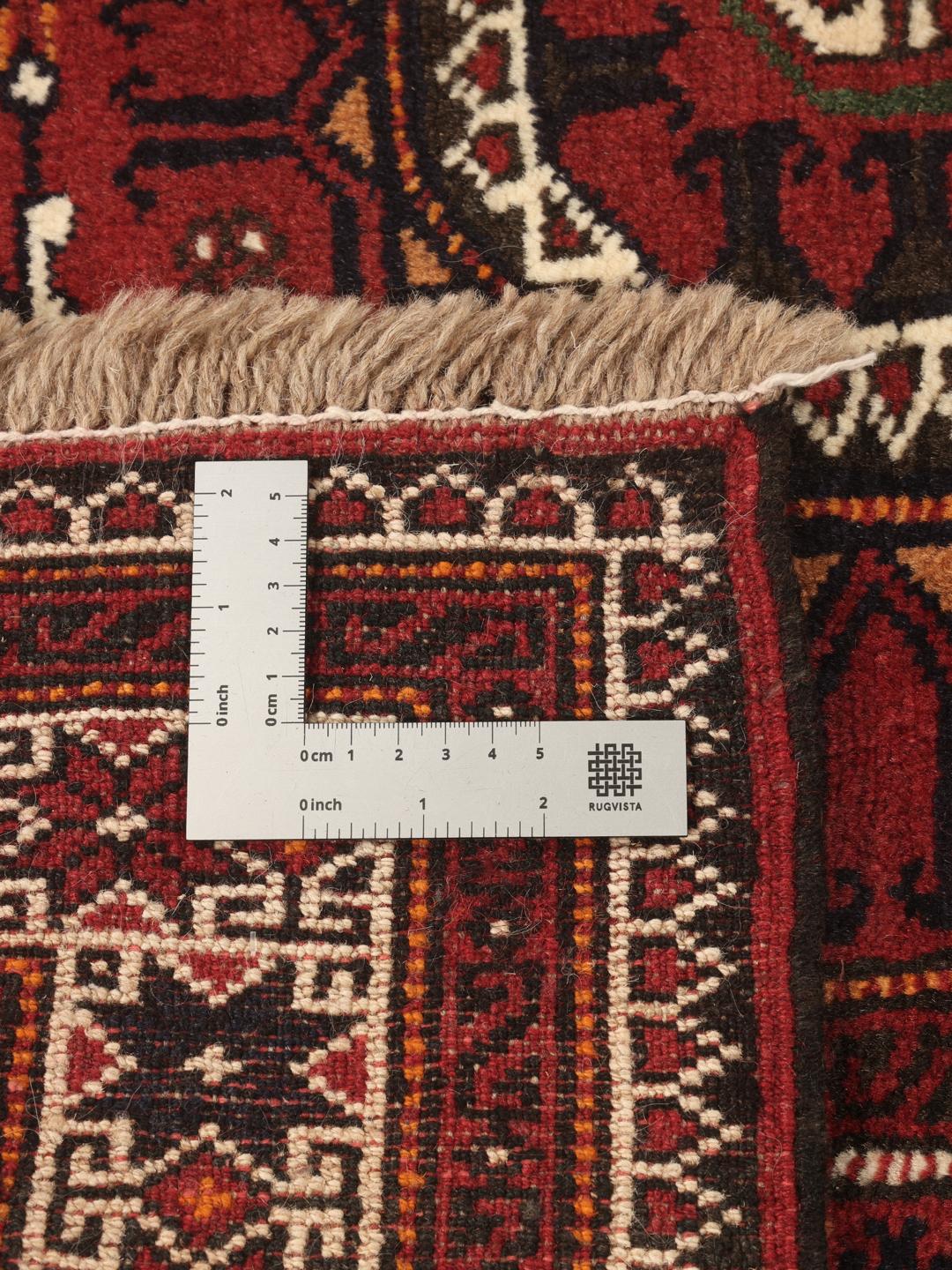 Håndknyttet mellemøstlig løber med geometriske motiver i rød uld.