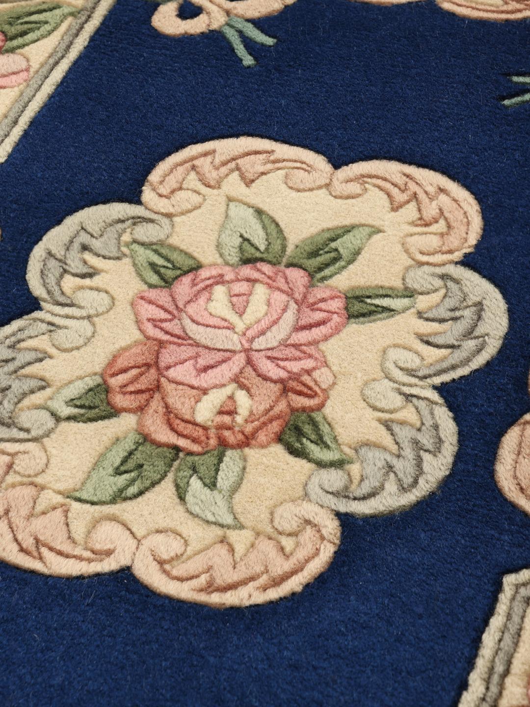Een handgeknoopt tapijt uit China met bloemmotieven op een diepblauwe achtergrond.