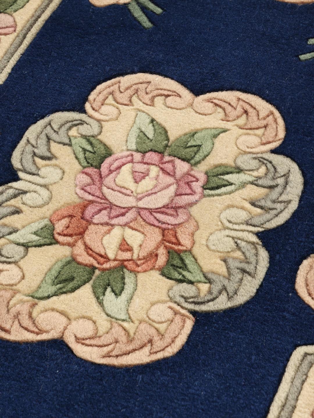 Håndknyttet kinesisk tæppe med blomstermotiver i blå og bløde pastelfarver