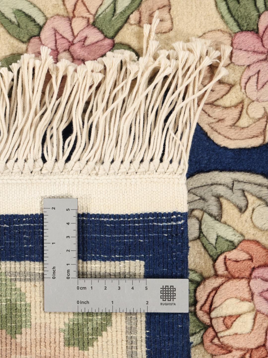 Håndknyttet kinesisk tæppe med blomstermotiver i blå og bløde pastelfarver