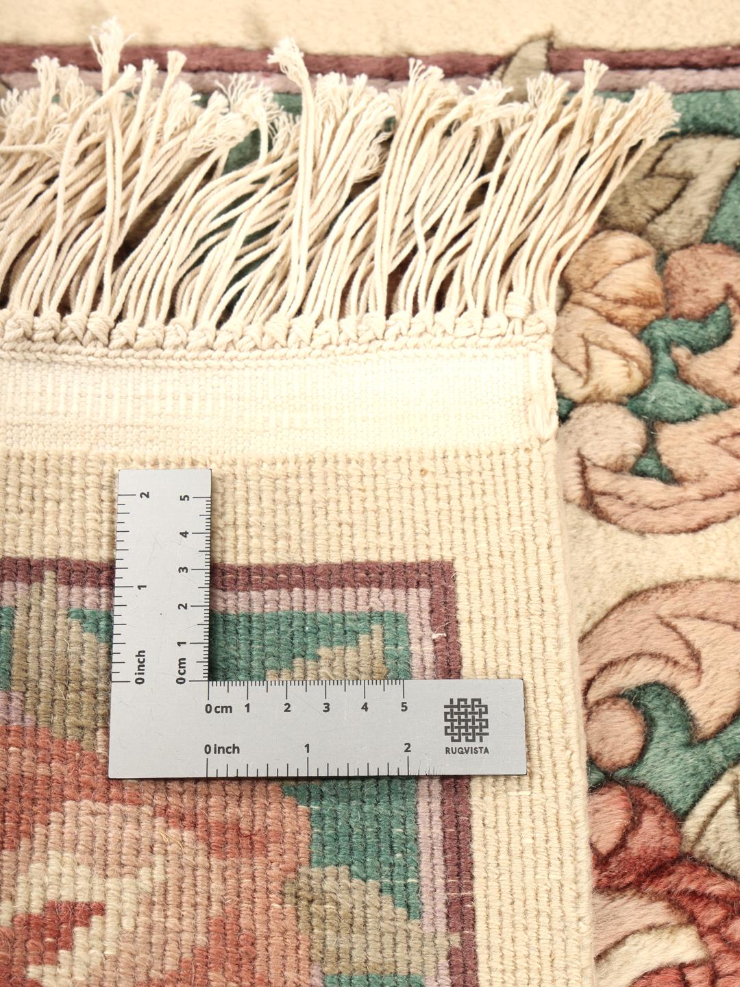Een rechthoekig handgeknoopt tapijt uit China met een bloemenpatroon in beige en groen.