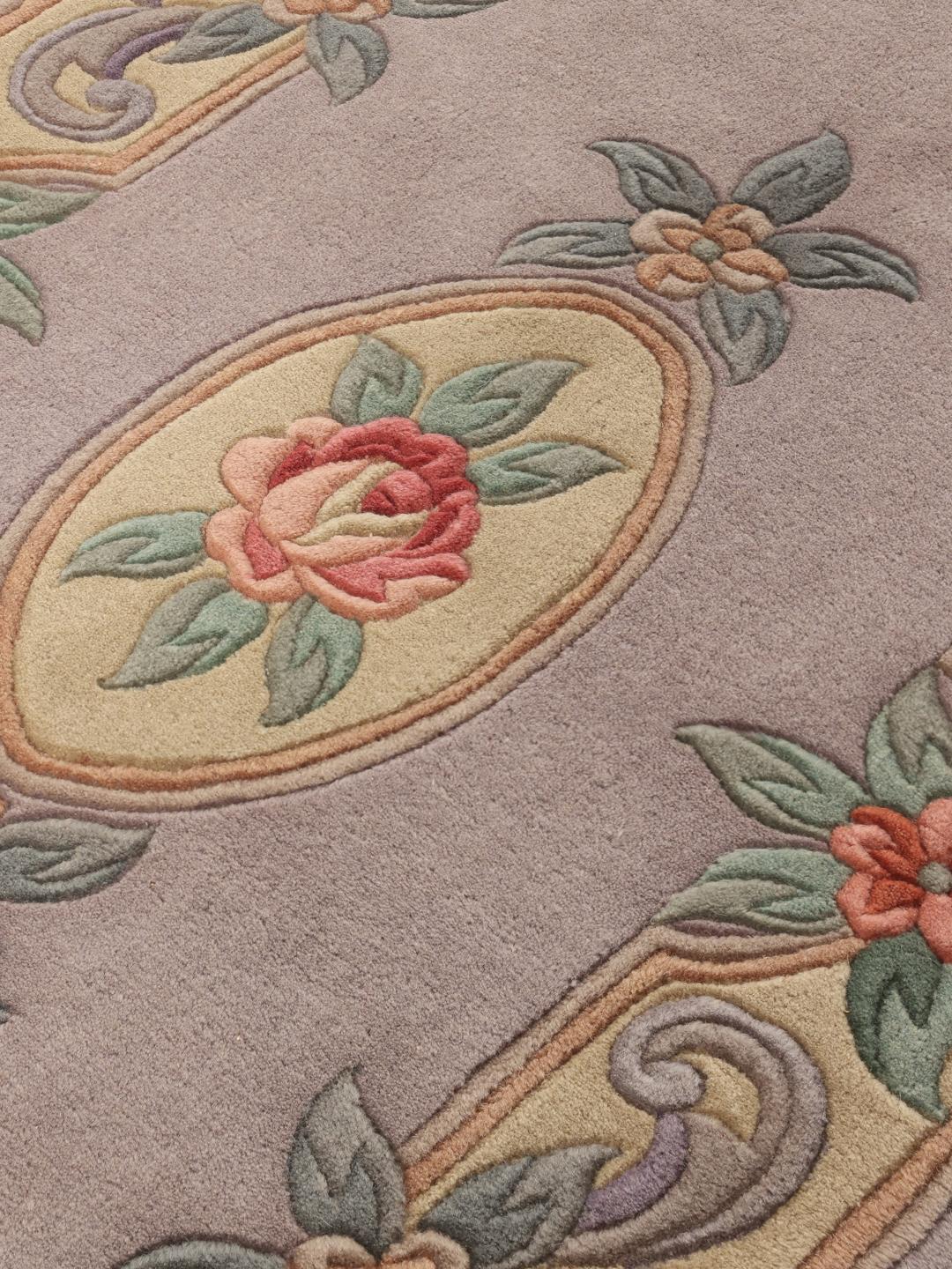 Et håndknyttet kinesisk tæppe med et blomstermedaljon-design i lyseblå og bløde pastelfarver.