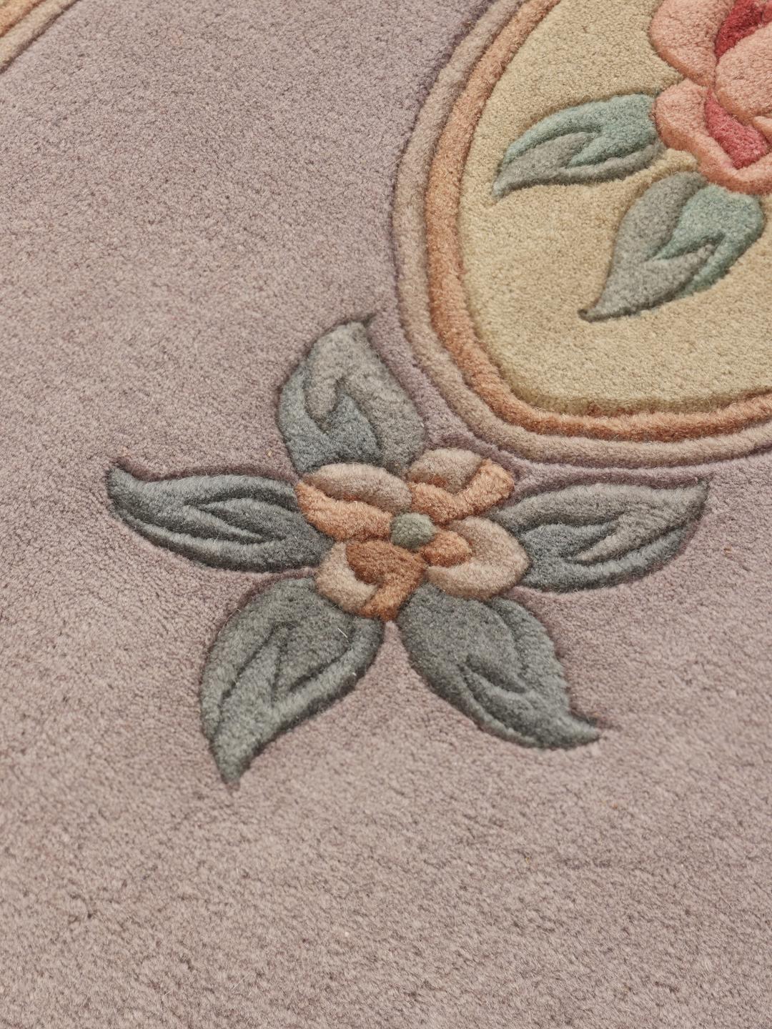Et håndknyttet kinesisk tæppe med et blomstermedaljon-design i lyseblå og bløde pastelfarver.
