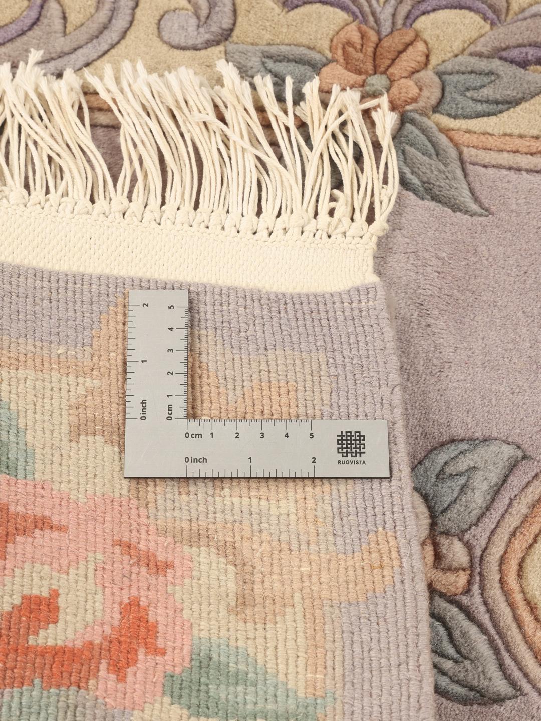 Et håndknyttet kinesisk tæppe med et blomstermedaljon-design i lyseblå og bløde pastelfarver.