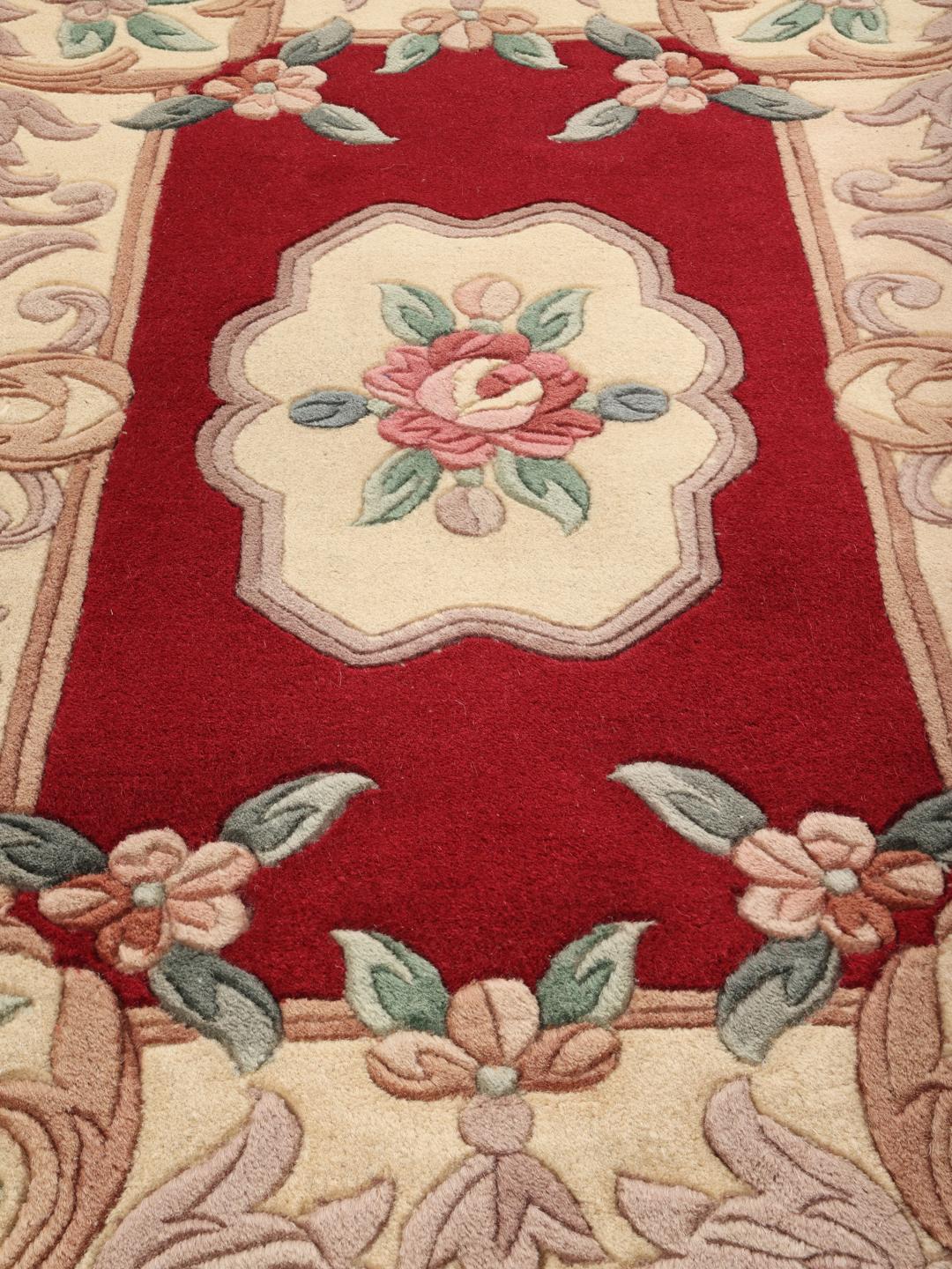 Hand-knotted rug from China with a red background and floral patterns