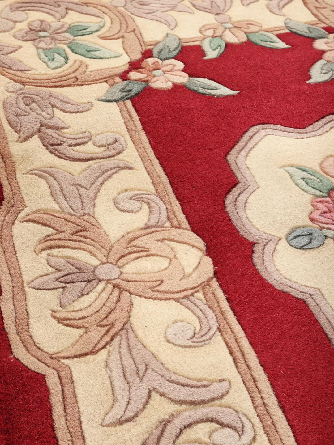 Hand-knotted rug from China with a red background and floral patterns