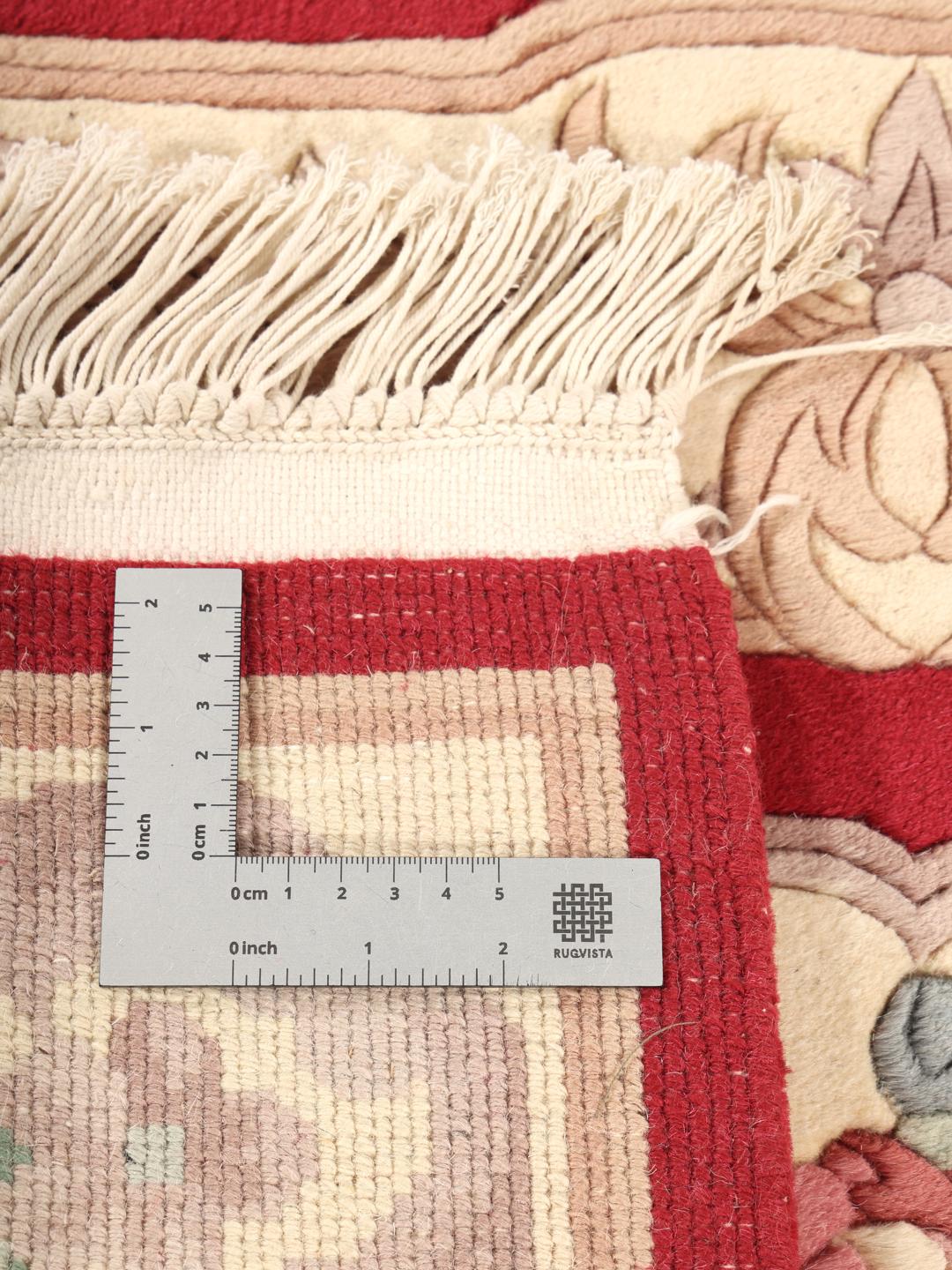 Hand-knotted rug from China with a red background and floral patterns