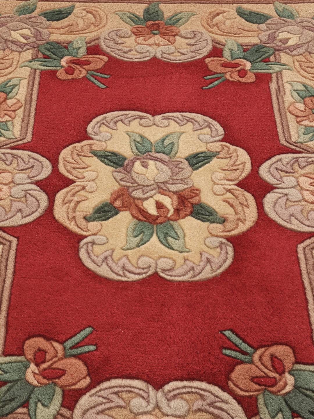 A unique rectangular hand-knotted rug from China with a red field and floral patterns.