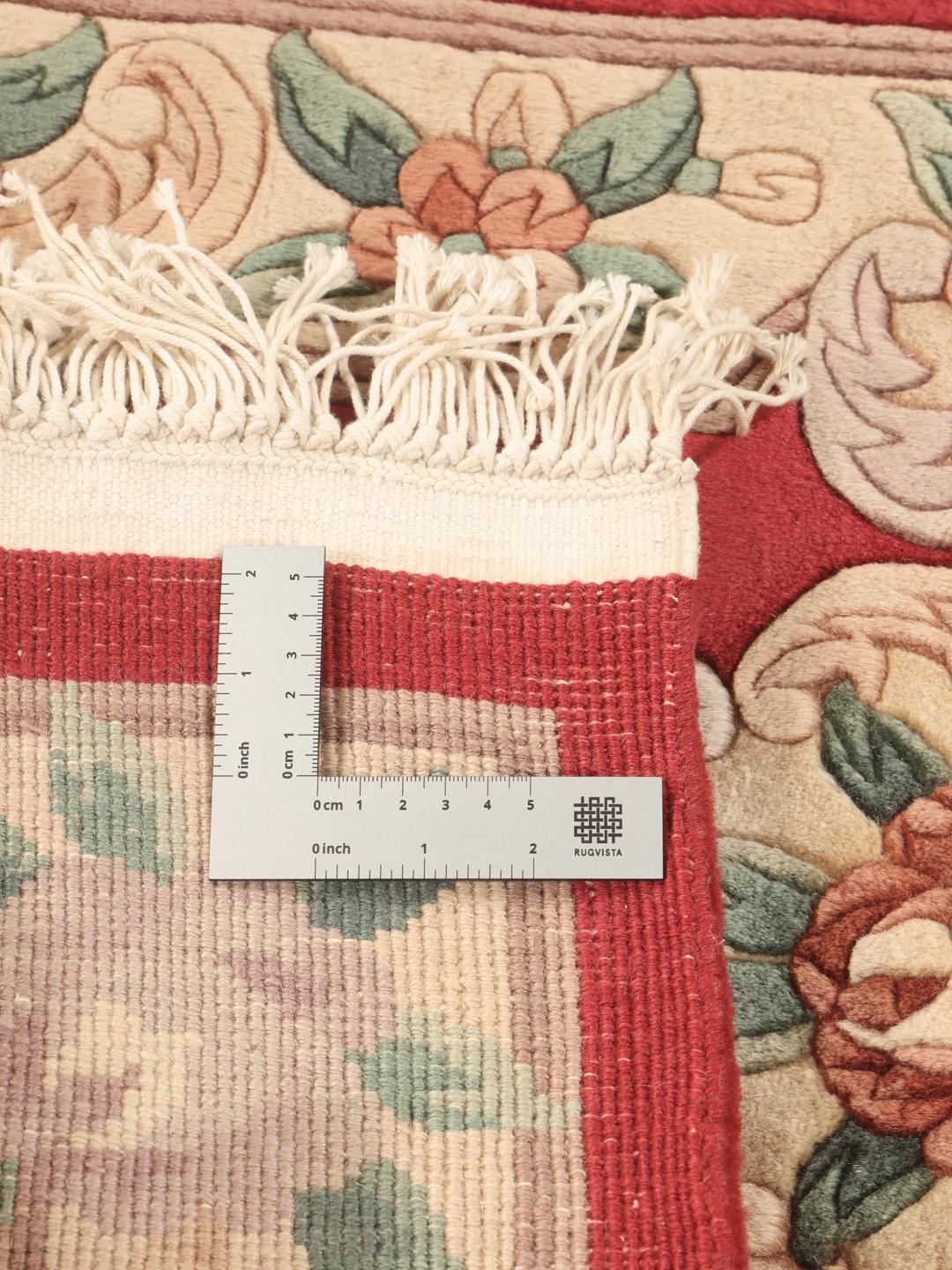A unique rectangular hand-knotted rug from China with a red field and floral patterns.