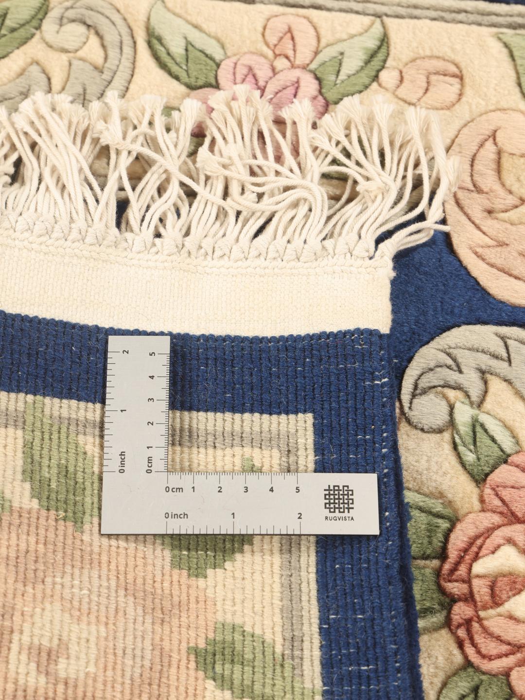 Hand-knotted Chinese rug featuring a floral pattern on a deep blue background