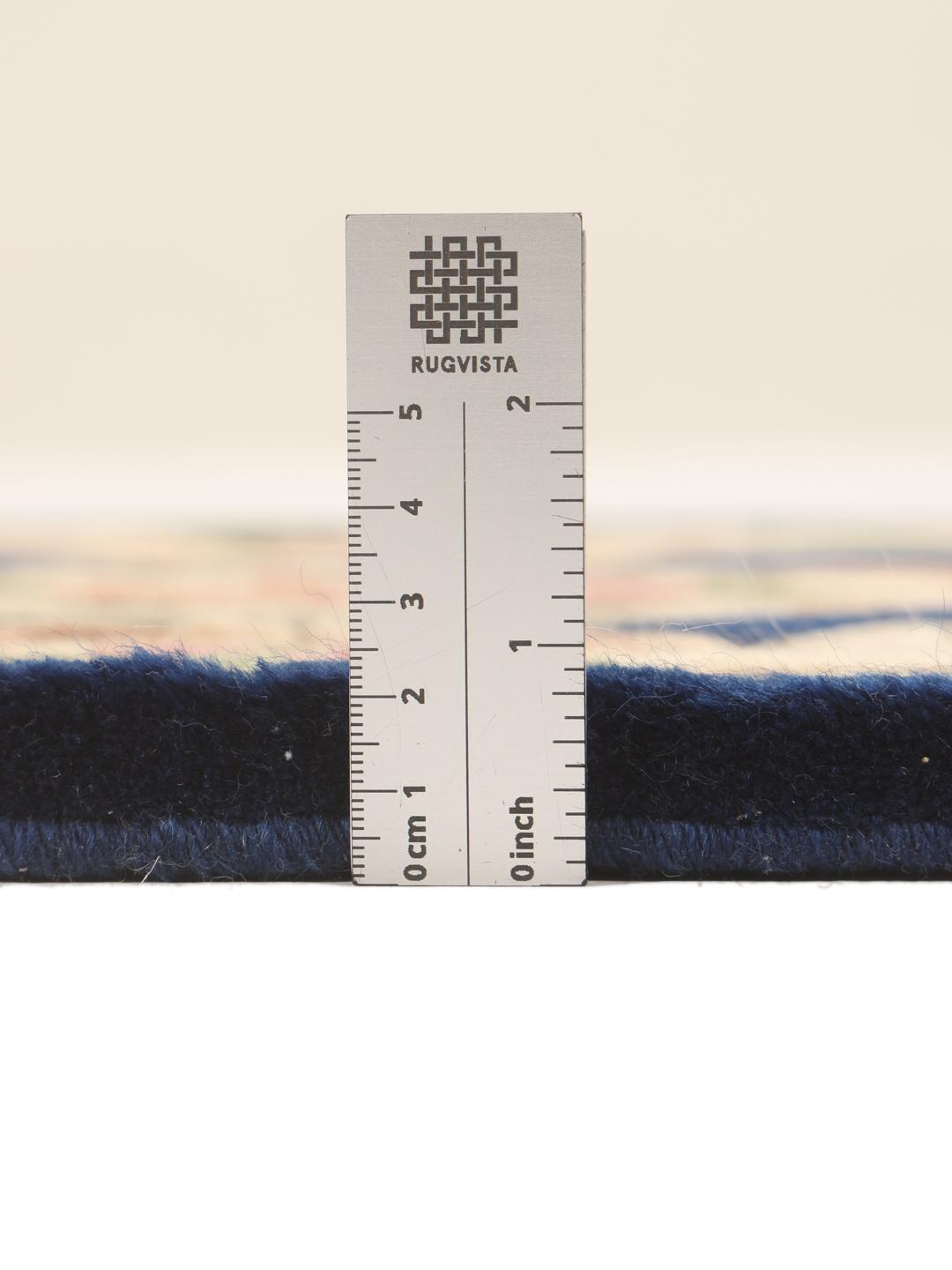 A rectangular, hand-knotted Chinese rug with a blue field and cream floral border.