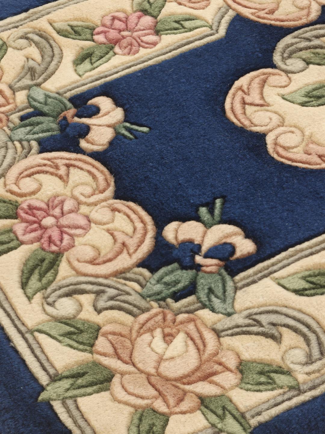 A rectangular hand-knotted rug from China featuring a blue field and floral pattern.