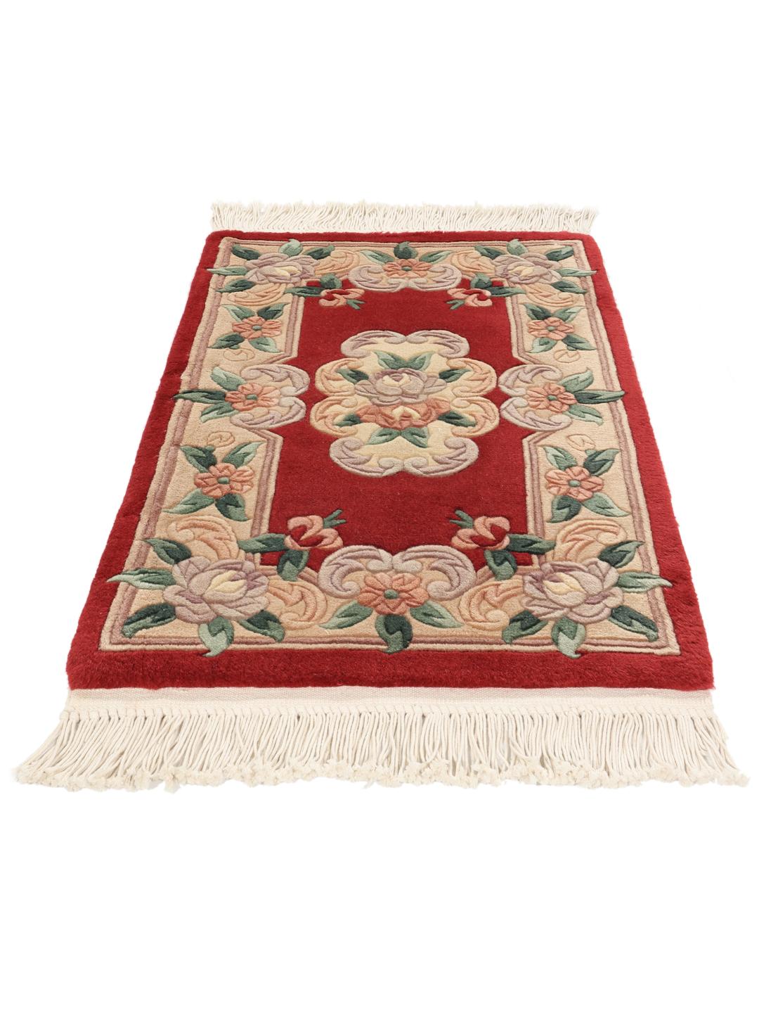 Un tapis chinois floral noué main dans des tons rouge et beige.