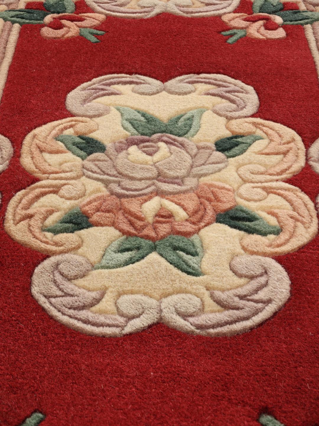 Un tapis chinois floral noué main dans des tons rouge et beige.