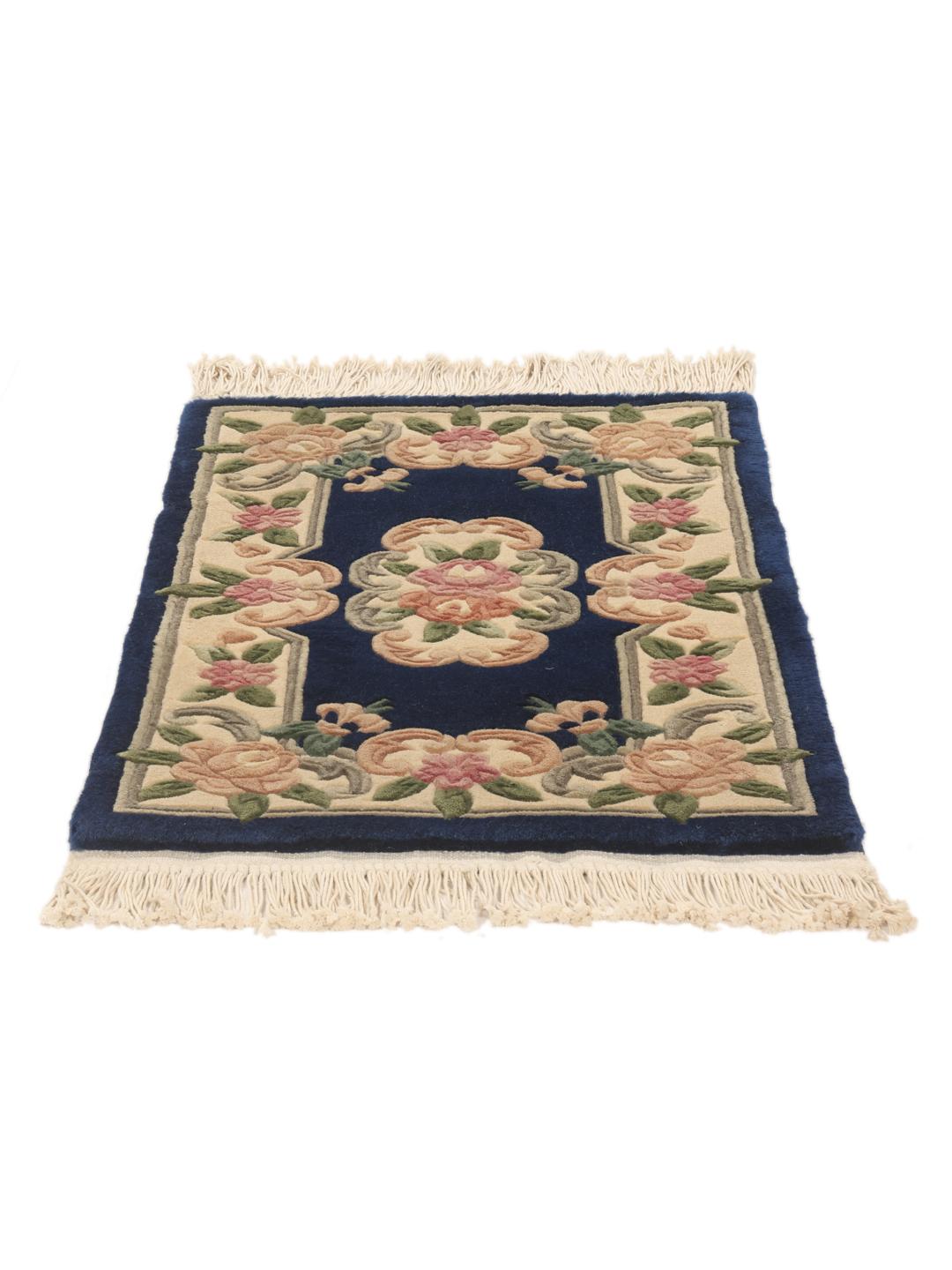 A hand-knotted floral Chinese rug with a deep blue field and cream border.