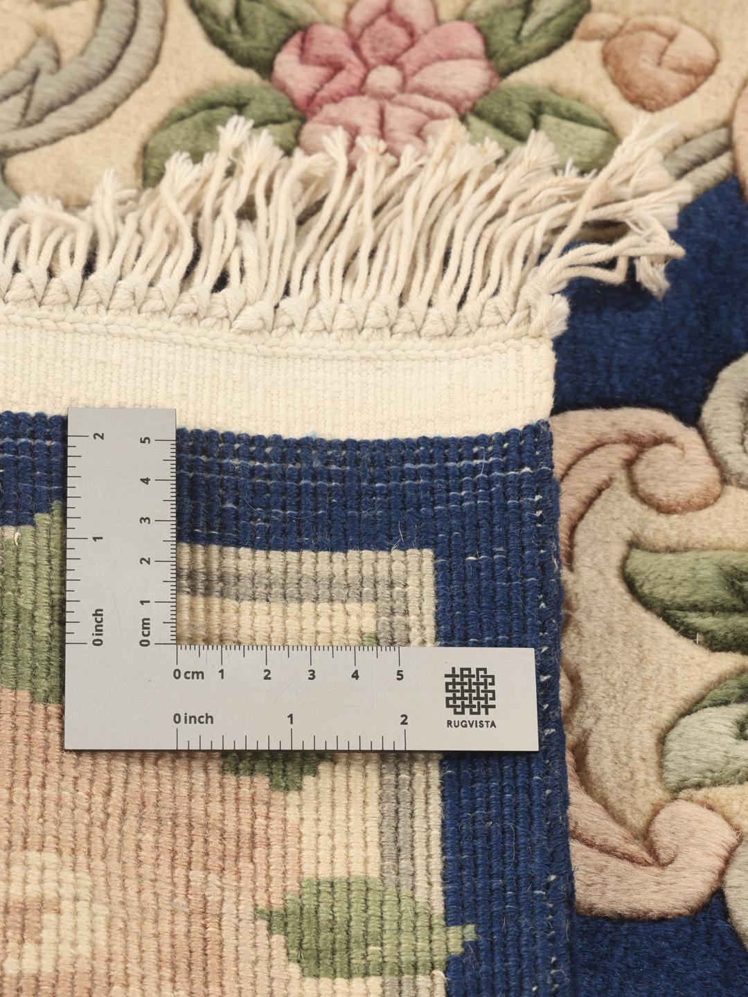 Handgeknoopt Chinees tapijt met een bloemenpatroon in blauw en beige.