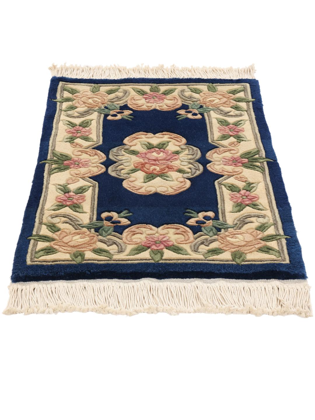 A hand-knotted Chinese rug with a blue field and floral pattern.