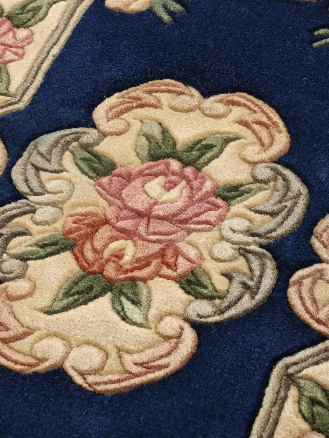 A hand-knotted Chinese rug with a blue field and floral pattern.