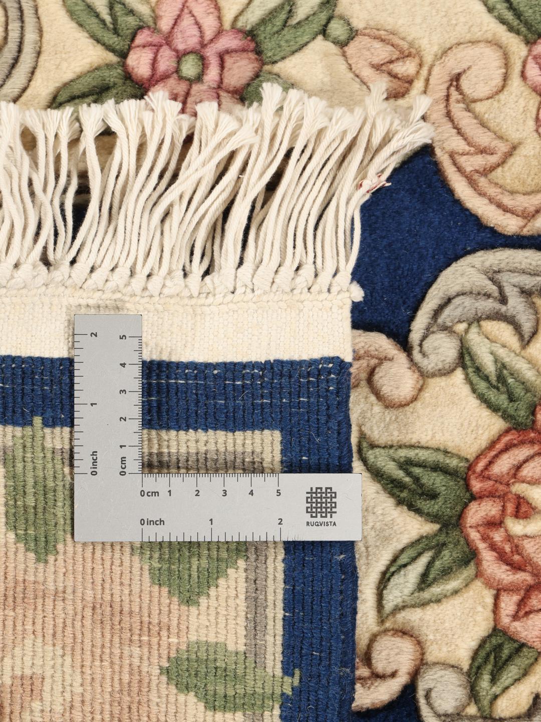 A hand-knotted Chinese rug with a blue field and floral pattern.