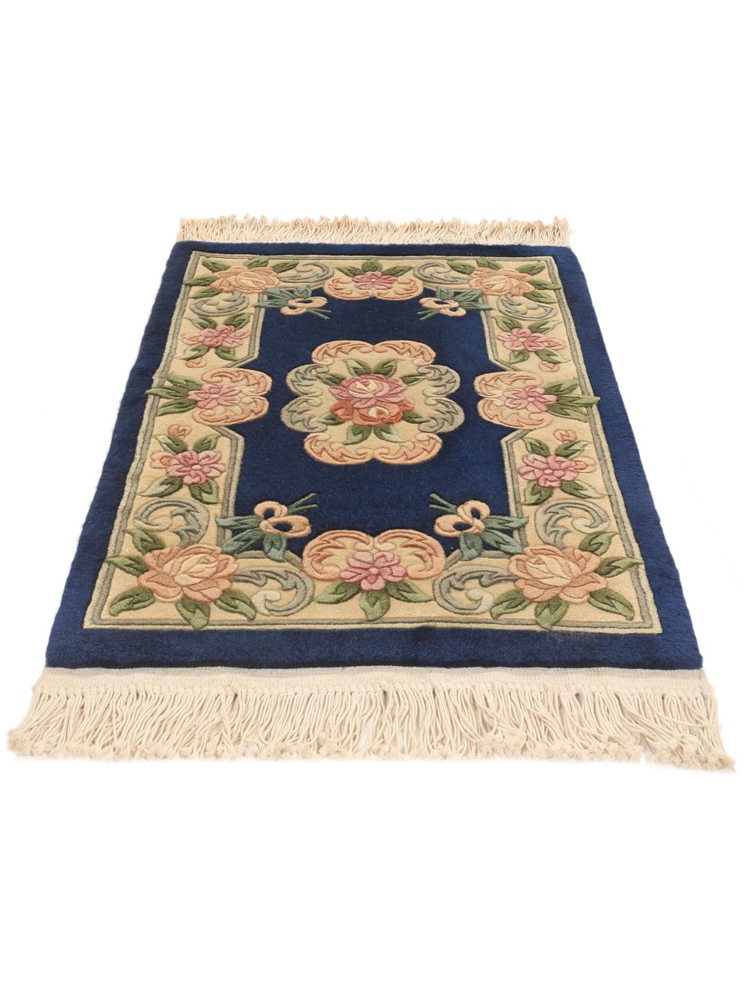 Een handgeknoopt Chinees tapijt met een diepblauw veld en verfijnde bloemmotieven.