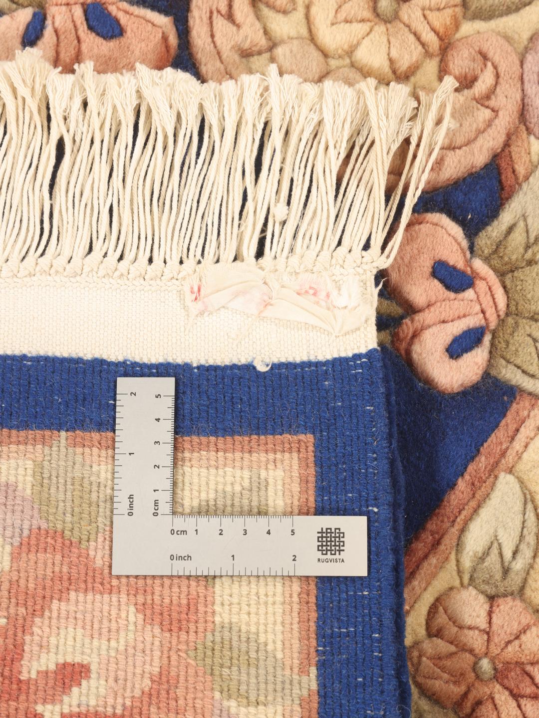 A rectangular hand-knotted rug from China with a blue field and floral pattern.