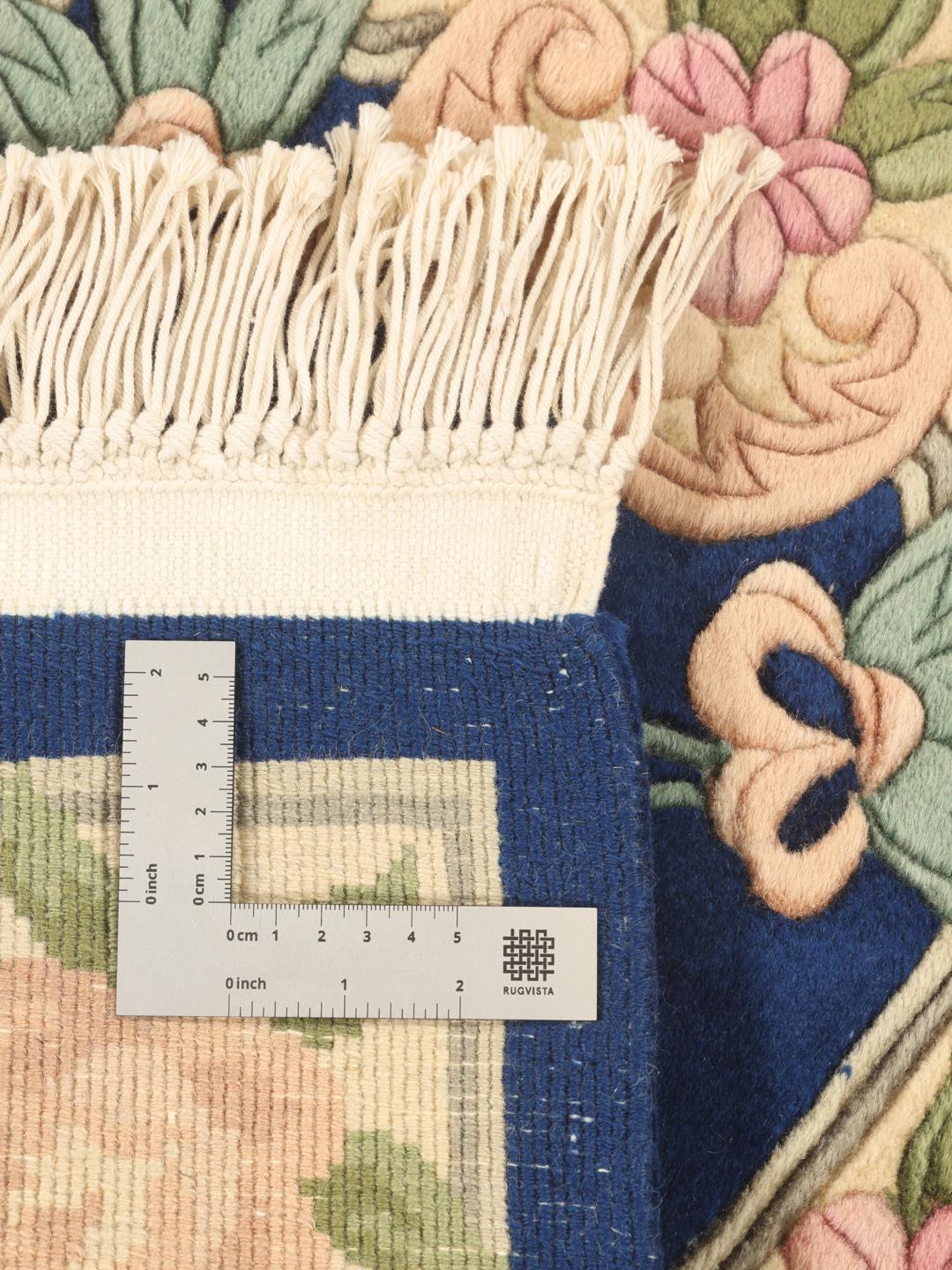 Hand-knotted Chinese rug with floral motifs in blue and soft pastel tones.