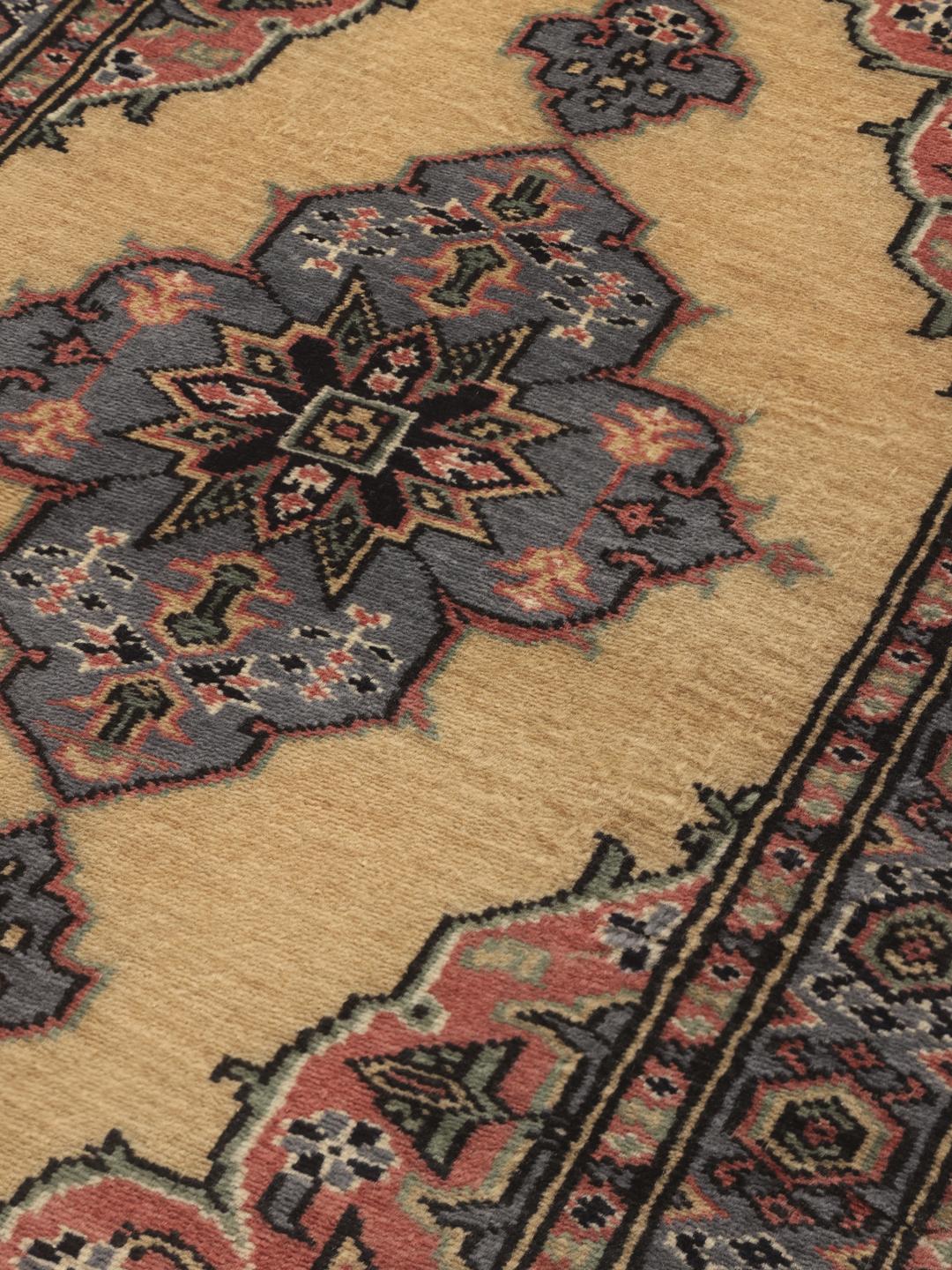 Hand-knotted Pakistan Bokhara rug with a beige field and medallion pattern