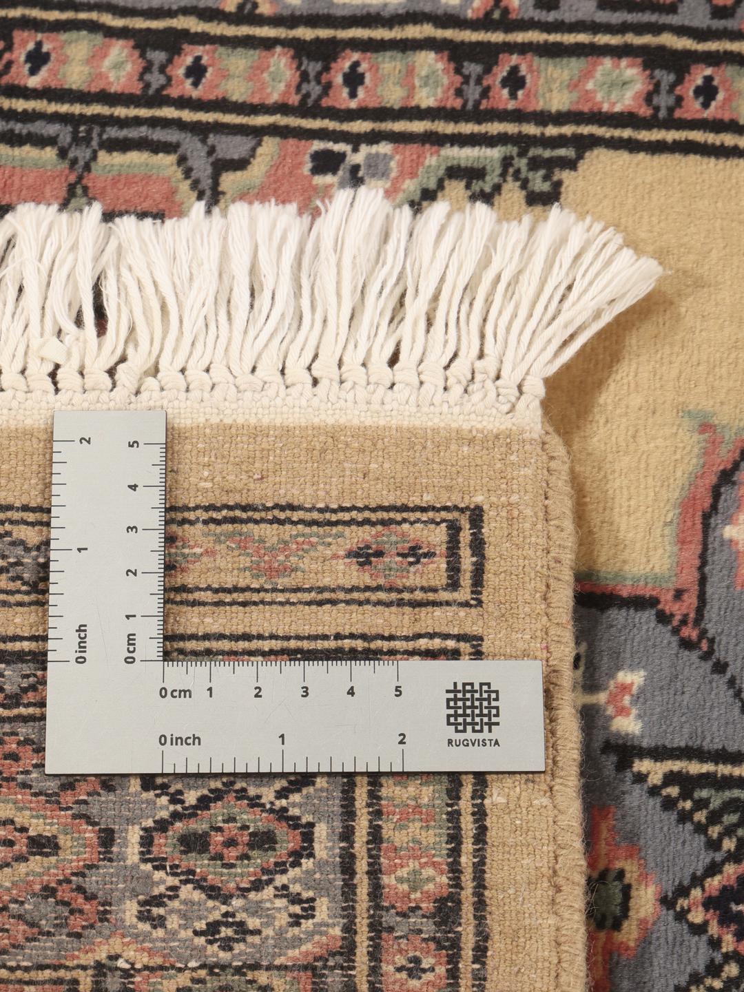 Hand-knotted Pakistan Bokhara rug with a beige field and medallion pattern