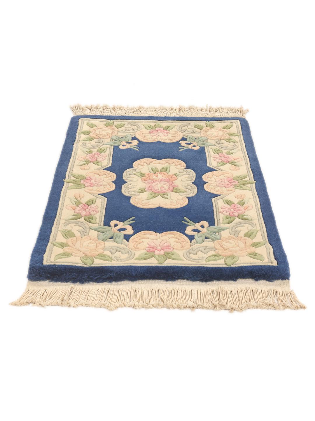 A rectangular Chinese rug featuring a blue field with delicate floral patterns in pink and green.