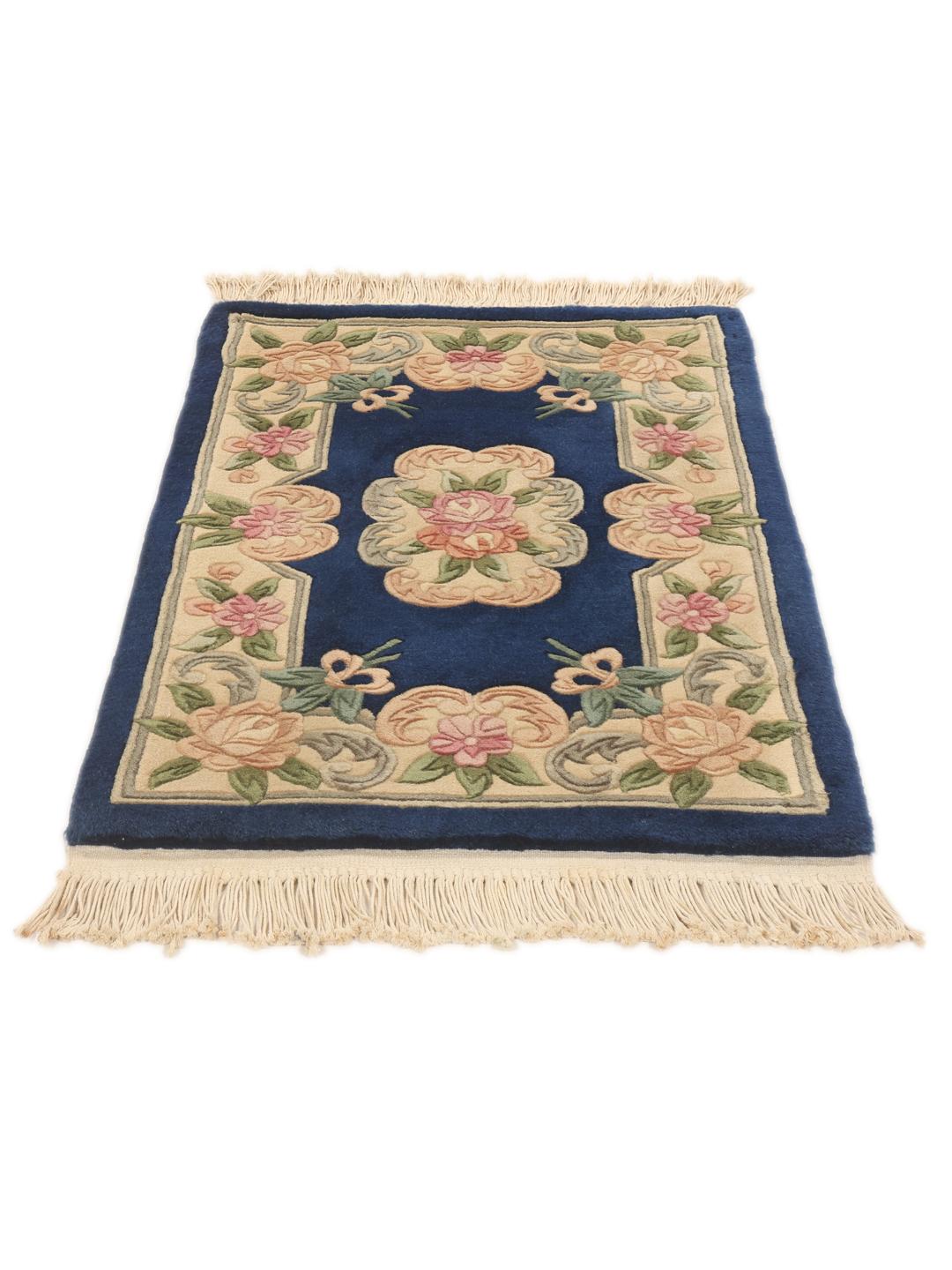 A rectangular Chinese rug featuring a blue field with delicate floral patterns in pink and green.
