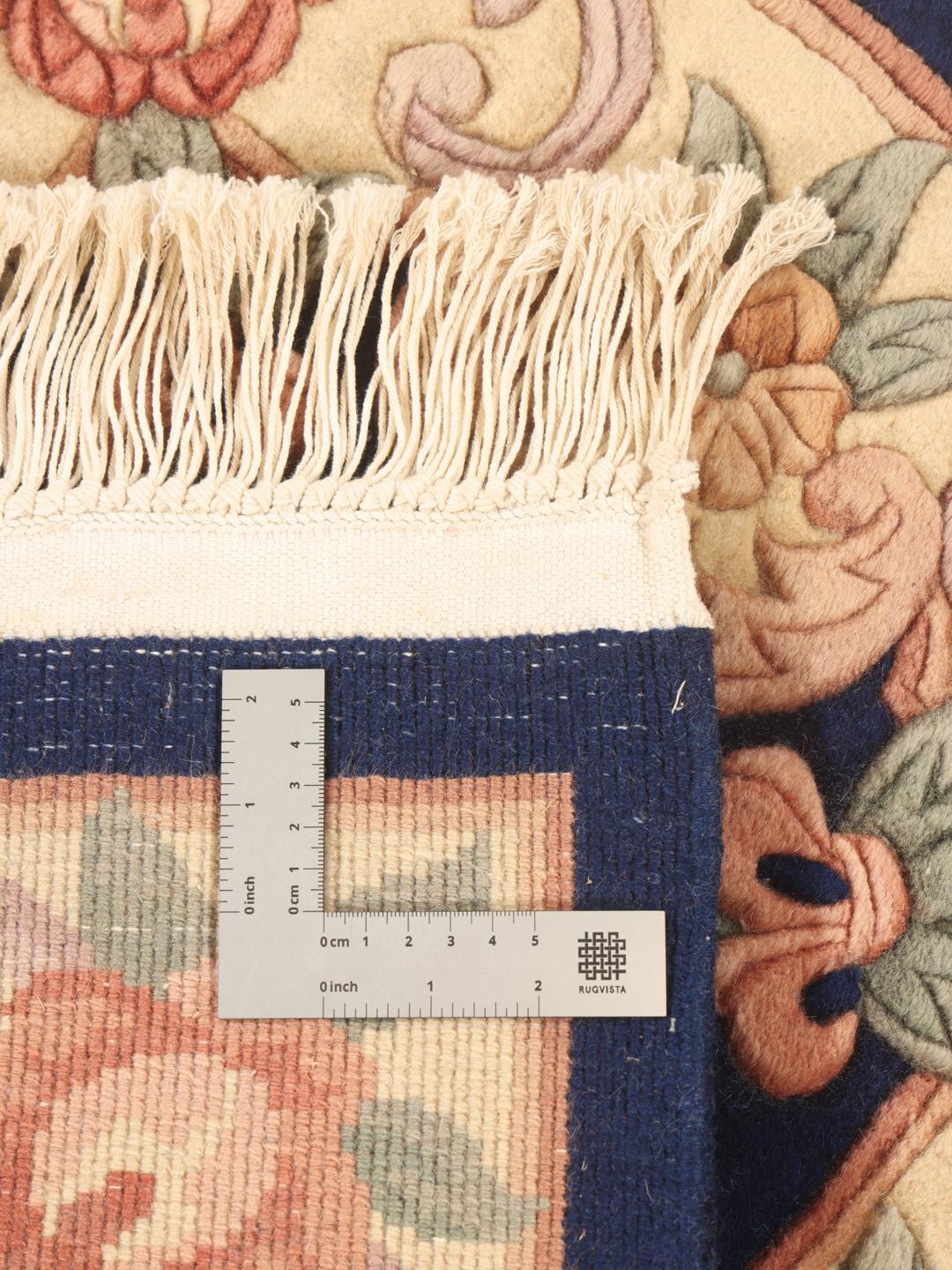A rectangular Chinese rug featuring a blue field with delicate floral patterns in pink and green.
