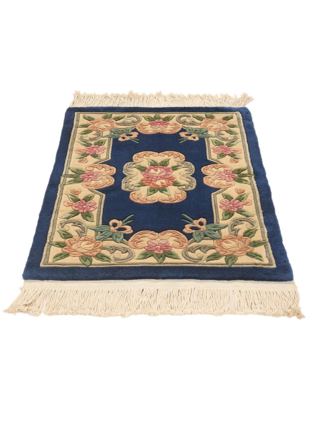 A rectangular hand-knotted Chinese rug with a floral pattern in blue and cream.