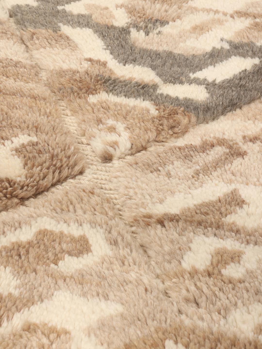 Handgeknoopt Marokkaans Berber tapijt met organische geometrische patronen in beige en bruine tinten.