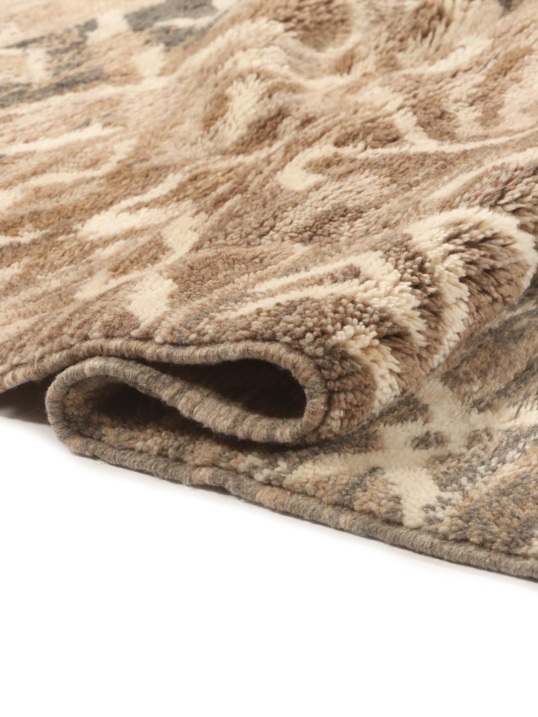 Handgeknoopt Marokkaans Berber tapijt met organische geometrische patronen in beige en bruine tinten.