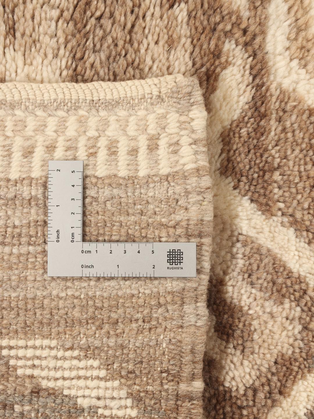 Handgeknoopt Marokkaans Berber tapijt met organische geometrische patronen in beige en bruine tinten.
