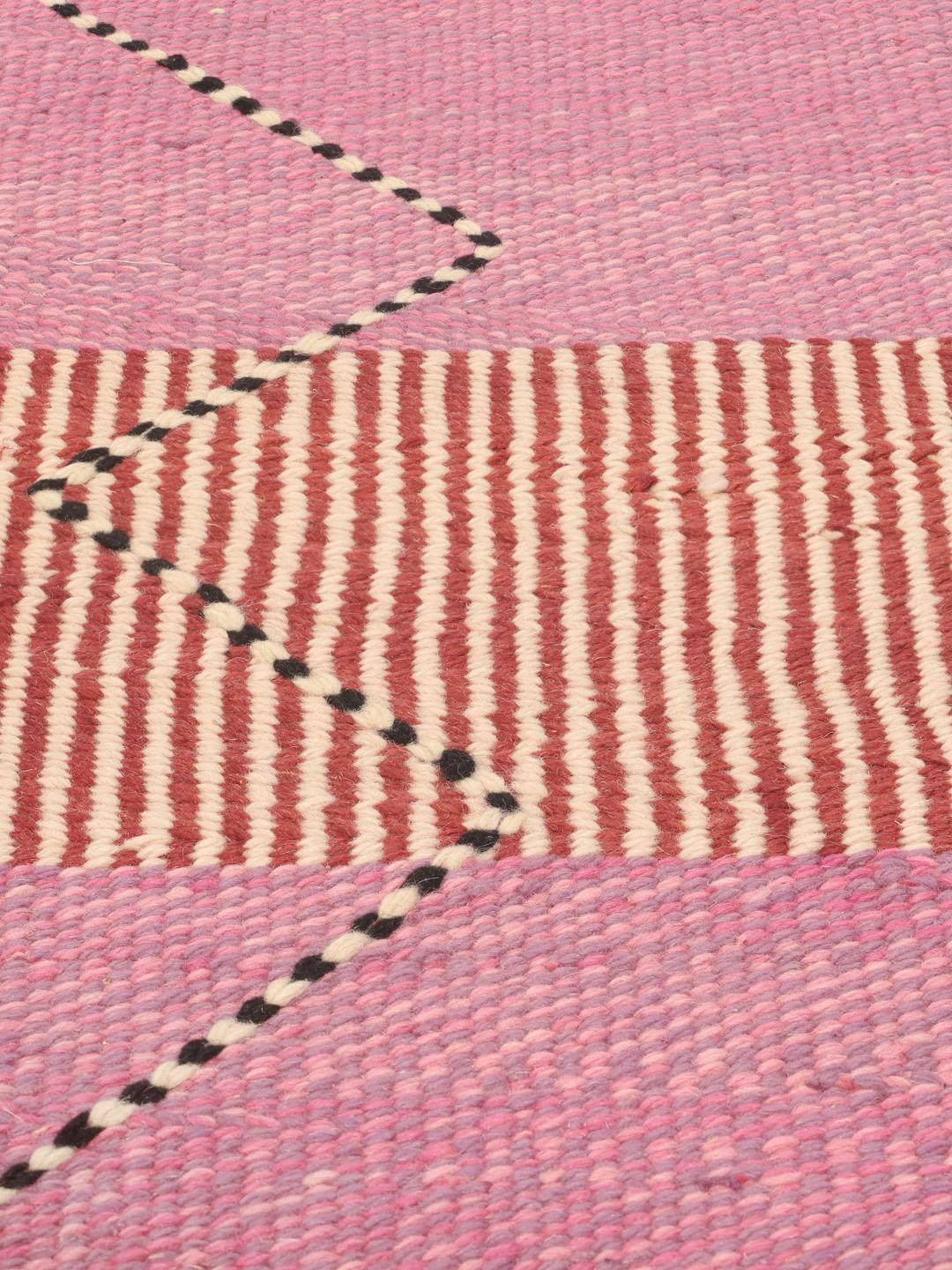 Tapis Kelim marocain tissé à la main avec des motifs géométriques en rose et rouge